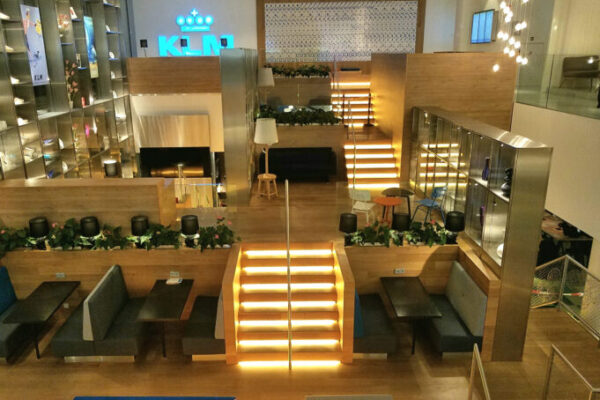 KLM Crown aiport lounge. A wooden room with spacious seats and lights.